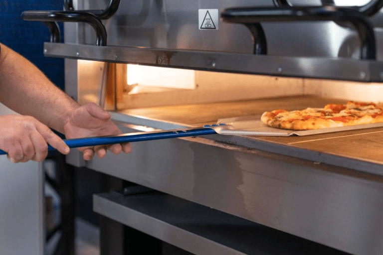 pala per pizza in azione su forno