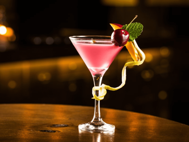 un cocktail rosa decorato con ciliegina